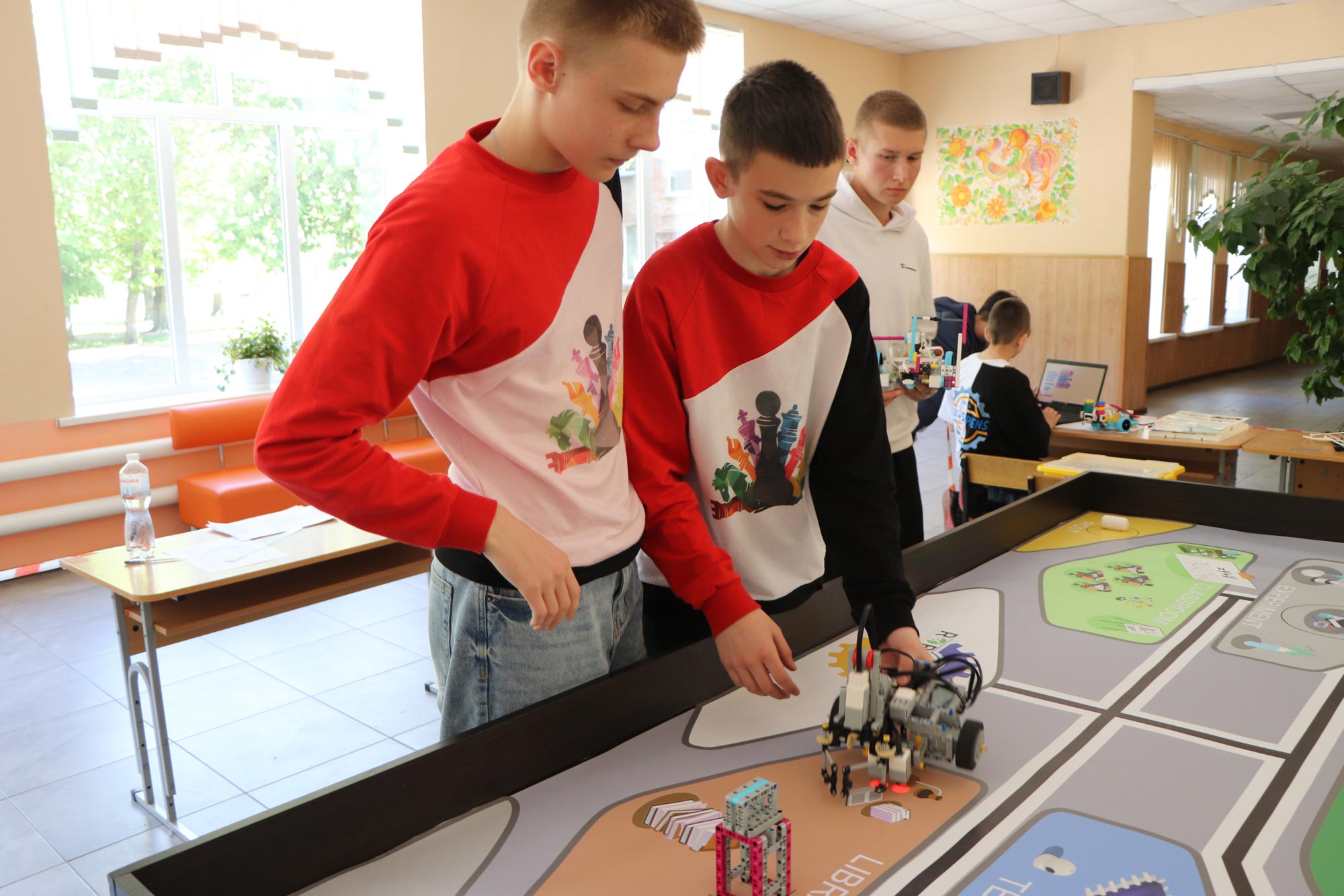 3 boys with a robot in their hands at a festival